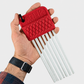 Red tool with white rods held by a hand on a light gray background